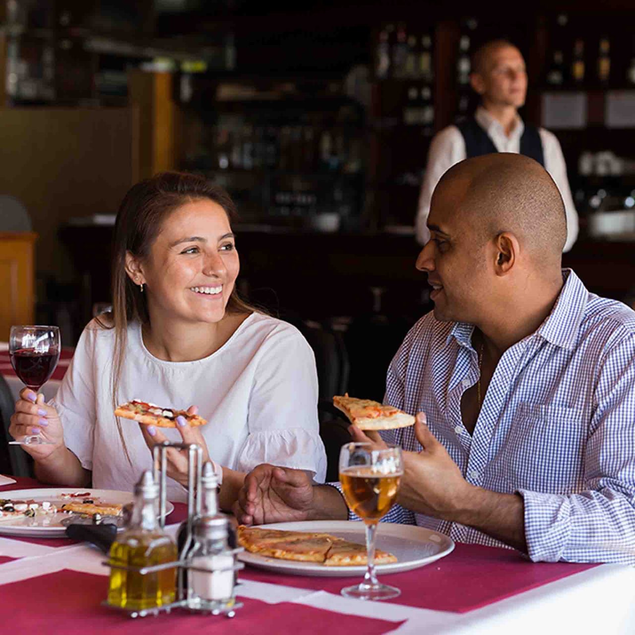 Man and woman eating pizza in restaurant