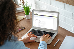 Woman typing on a laptop on a desk