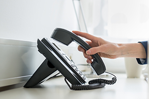 someone picking up a landline phone