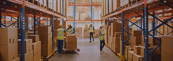 4 people in hi-vis jackets and hard hats taking boxes off and putting boxes on shelves in a warehouse